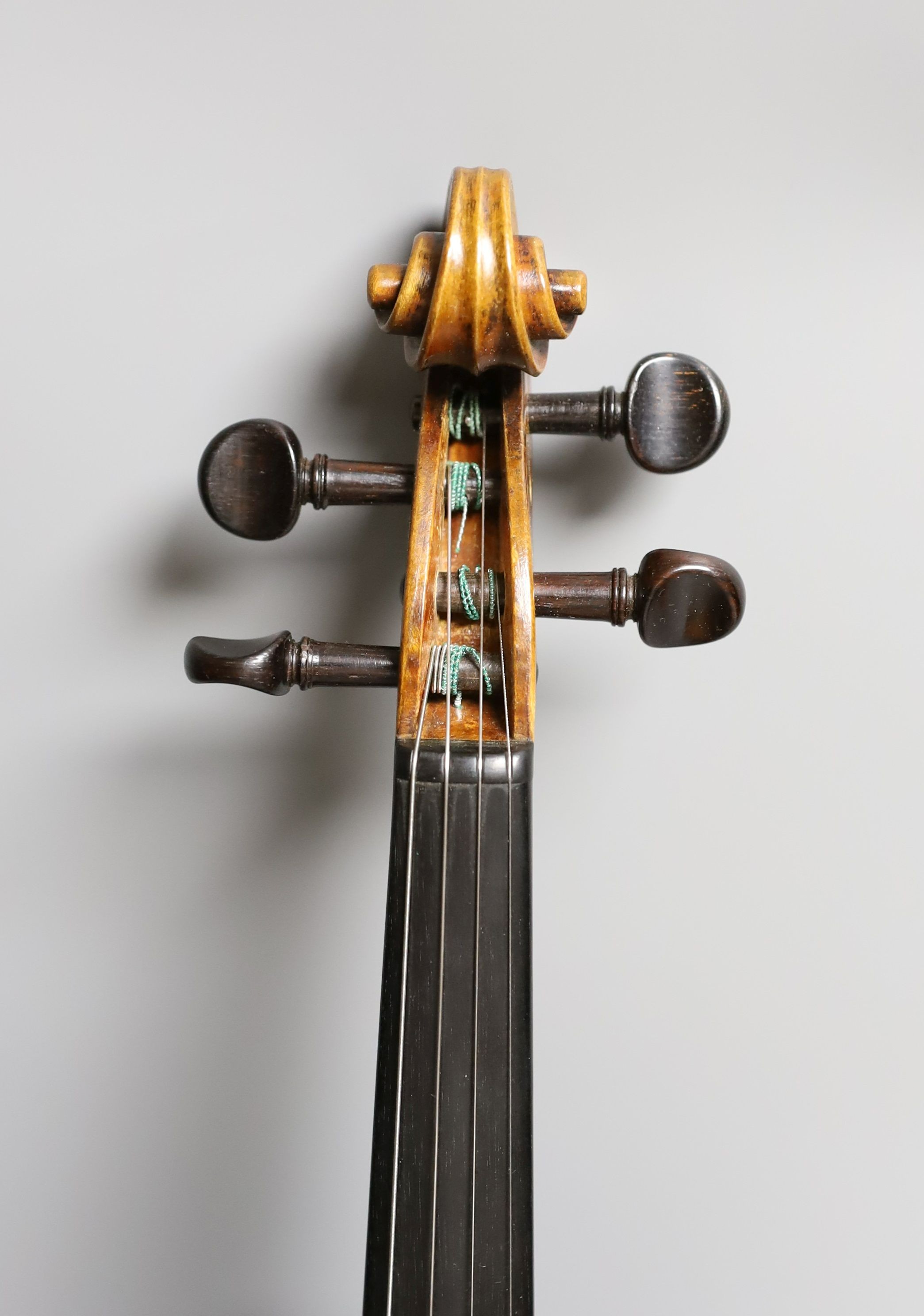 A 19th century violin labelled JB Guadagnini, back measures 35cm, with two bows, one silver-mounted.